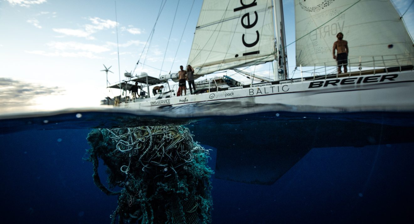 plastic waste in sea beside yacht