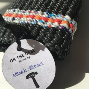 Woven recycled plastic case with weaver name on tag