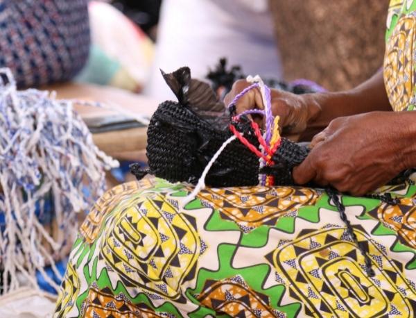Sunglasses case being woven by artisan out of recycled plastic and water sachets