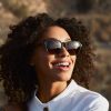 Smiling woman wearing green square sustainable sunglasses