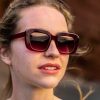 woman wearing Berry Purple Pink coloured rectangle sunglasses with matching lenses. Made from eco friendly materials