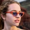 woman wearing Fashion forward pink cateye sunglasses with light blue lenses. Made for eco friendly materials