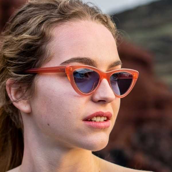 woman wearing Fashion forward pink cateye sunglasses with light blue lenses. Made for eco friendly materials