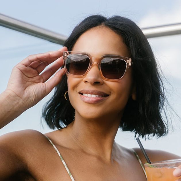 Woman wearing stylish square oversized sunglasses in transparent pink and brown tinted lenses